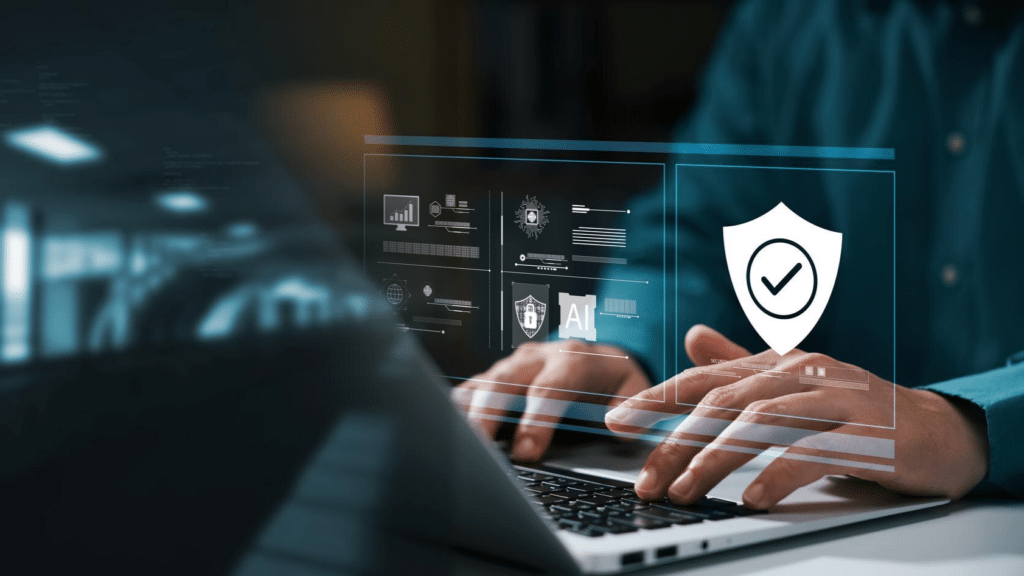 A imagem mostra uma pessoa usando um laptop, com uma interface digital holográfica projetada em frente à tela, representando um ambiente de segurança cibernética corporativa. Elementos visuais, como gráficos, ícones de proteção (escudo), inteligência artificial (AI) e sistemas de segurança, são exibidos no espaço acima do teclado. O foco da imagem é na tecnologia avançada de proteção de dados e segurança digital. O fundo é levemente desfocado, destacando a interação do usuário com a interface digital de segurança.