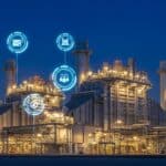 Planta industrial iluminada à noite com ícones digitais flutuantes representando automação, comunicação e segurança, simbolizando indústria 4.0.