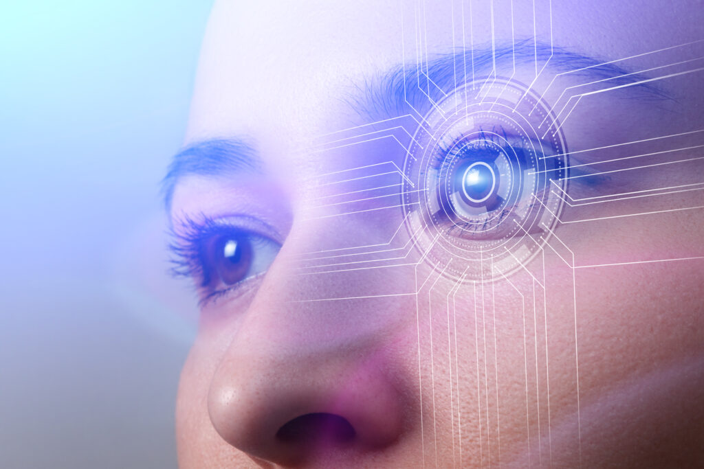 Close-up do rosto de uma pessoa, com foco nos olhos. O olho direito está sobreposto por elementos gráficos futuristas circulares e linhas digitais, representando tecnologia de reconhecimento ocular e biometria.