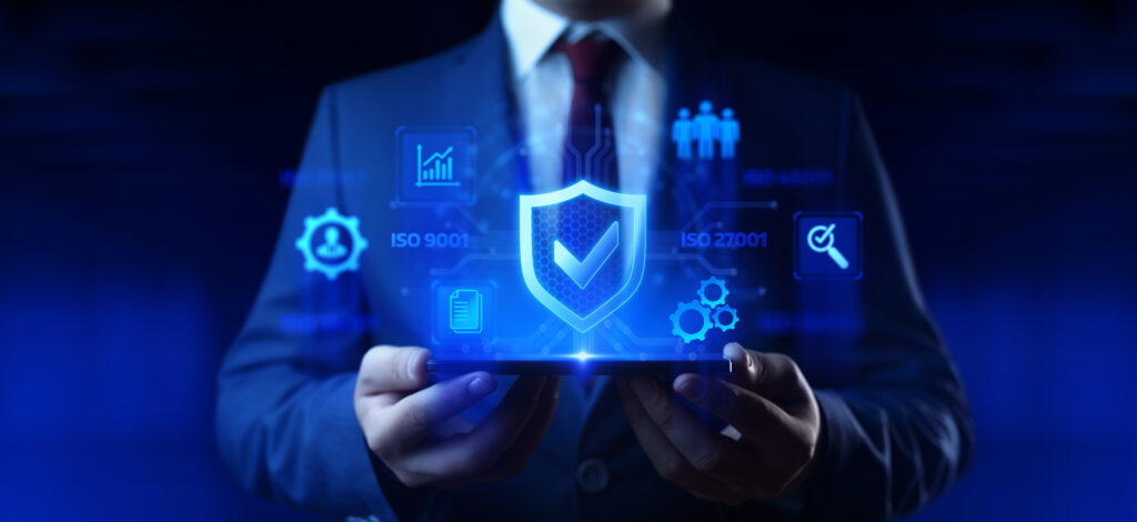 Homem de terno segurando tablet com ícones de segurança digital e textos “ISO 9001” e “ISO 27001”.